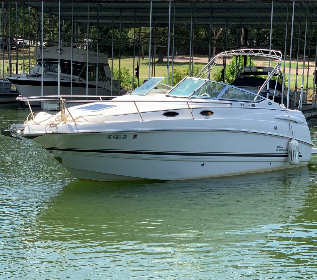 White mini yacht cruiser boat rental idling in water at Lake Lewisville